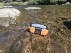 blackfire portable waterproof speaker on rock in river