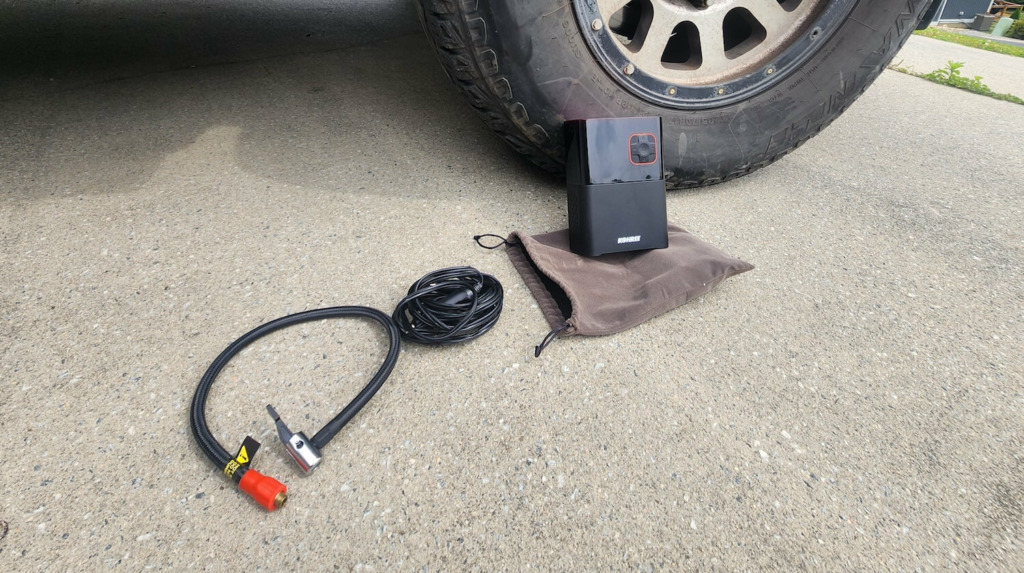 portable tire inflator with fittings on the ground next to it