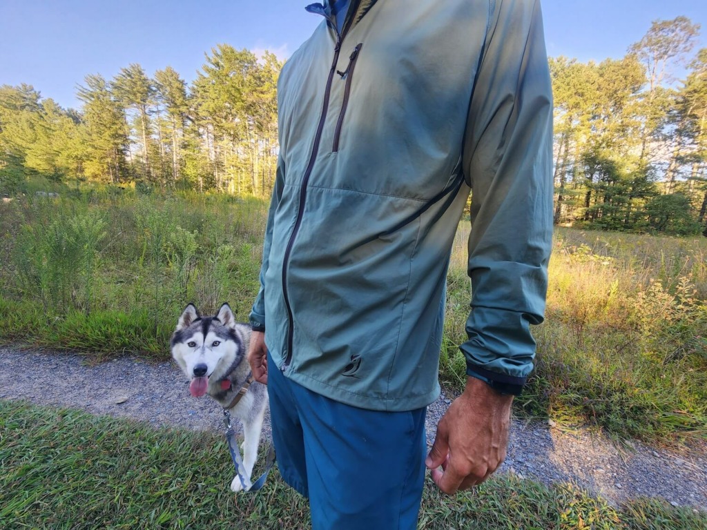Man and dog looking at camera in meadow