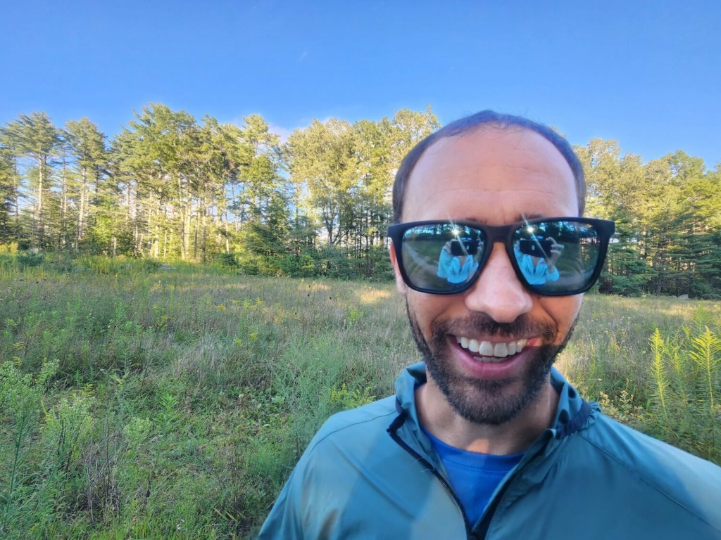 man smiling wearing knockaround sunglasses