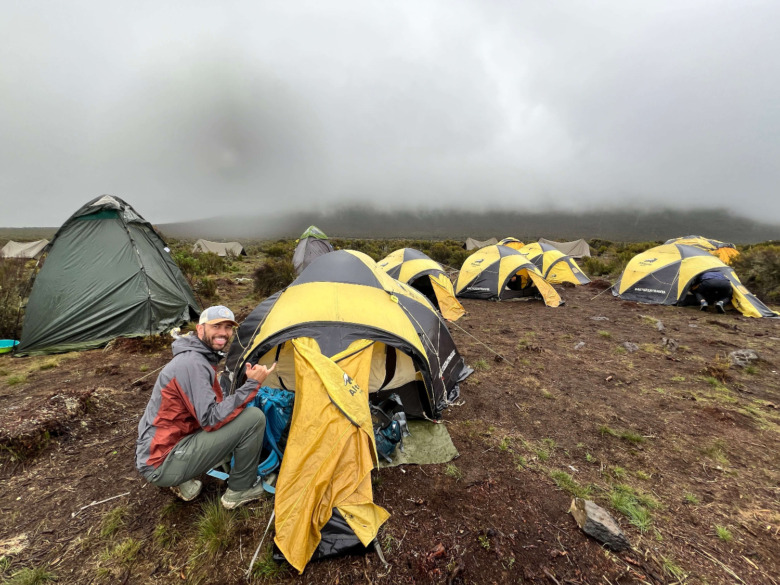 The Backpack Guide in the Tushar rain jacket outside a tent