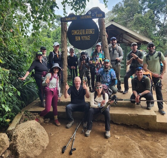 Group of climbers at Mweka Gate Sign after their Kilimanjaro trip