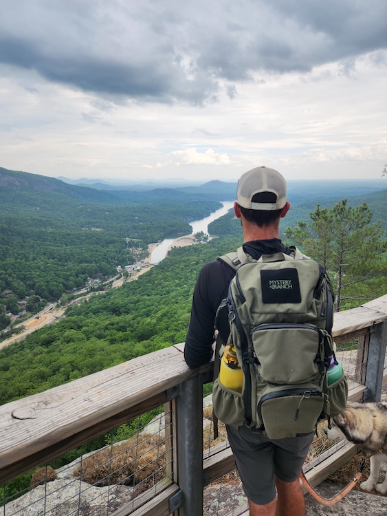 Man looking over Lake Lure NC wearing Mystery Ranch Blitz 30 backpack