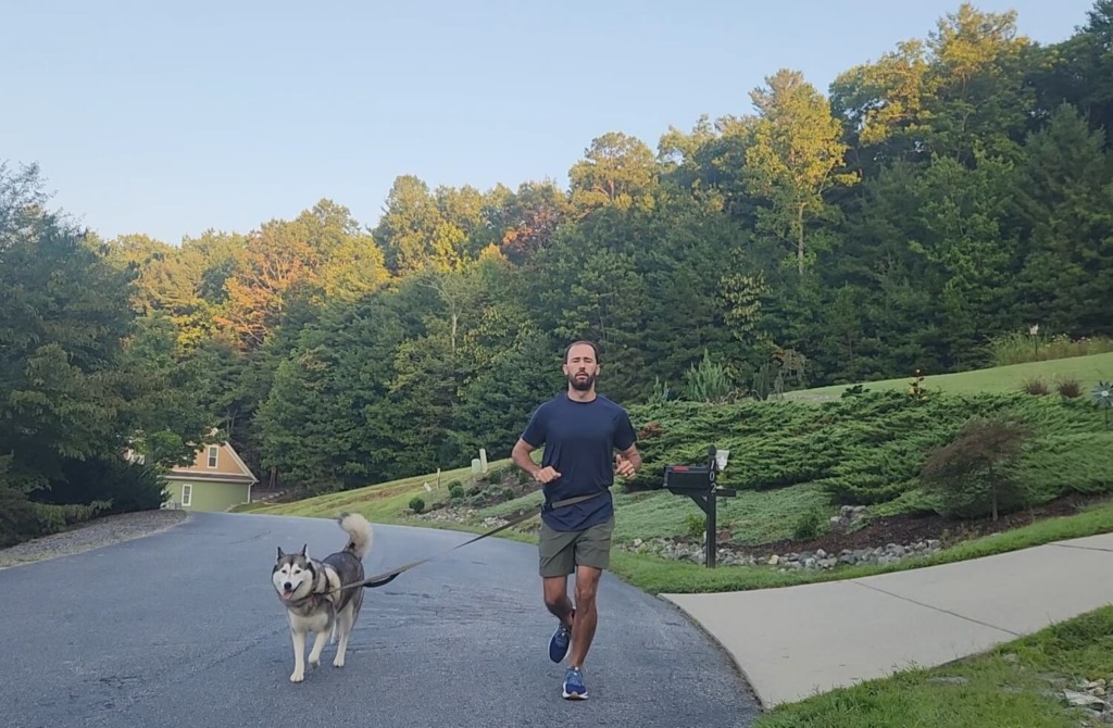 Man running with dog wearing ASRV apparel for review